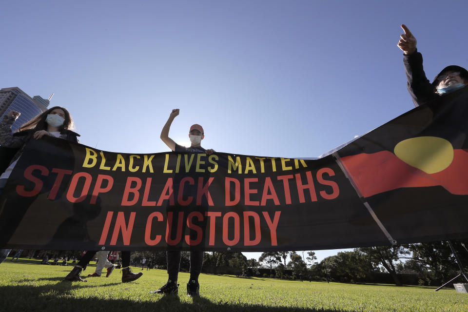 People hold a banner as thousands gather at a rally supporting the Black Lives Matter and Black Deaths in Custody movements in Sydney, Sunday, July 5, 2020. (AP Photo/Rick Rycroft)