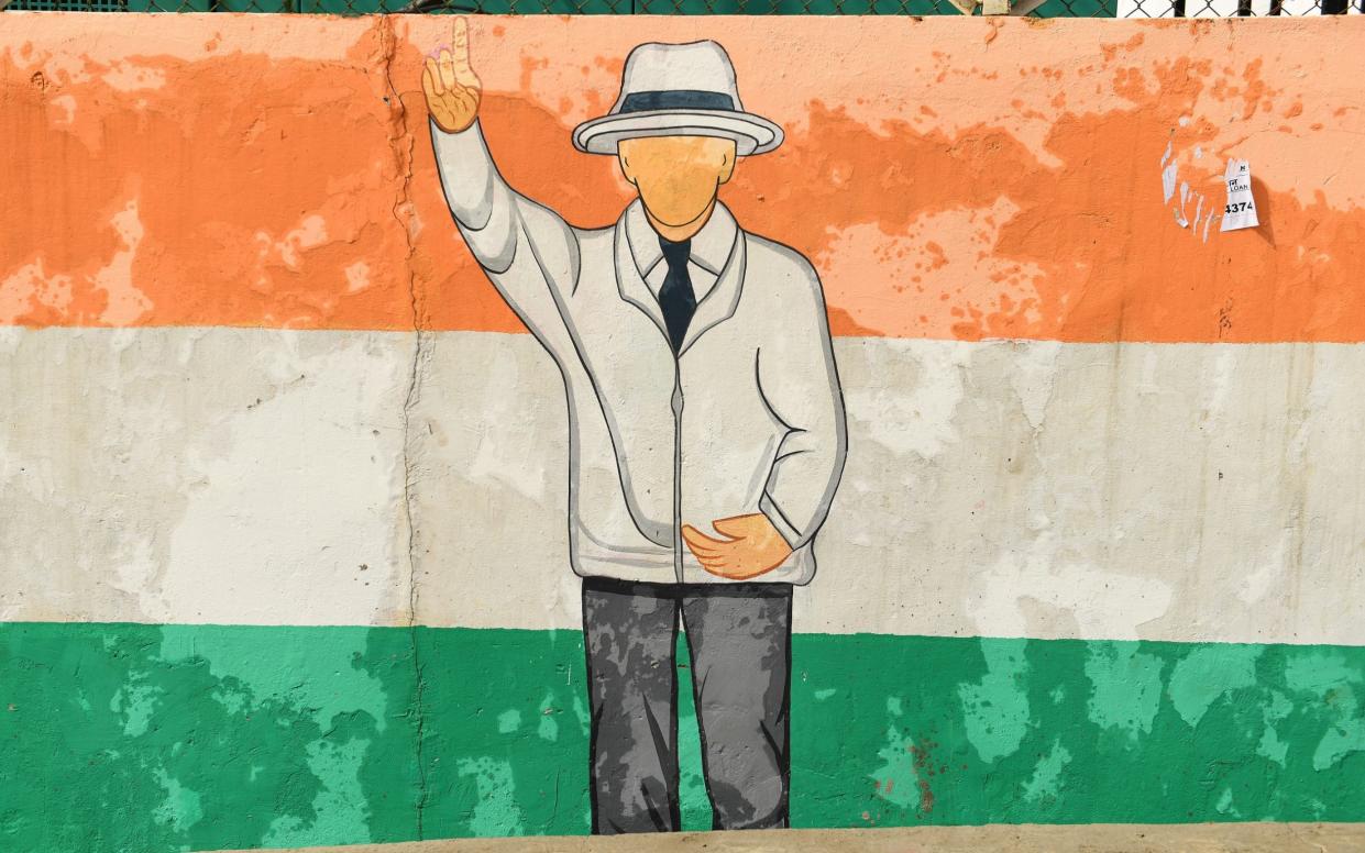 A mural on a wall outside the Himachal Pradesh Cricket Association Stadium in Dharamsala shows an umpire raising his hand against the backdrop of the Indian flag