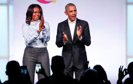 Former U.S. President Barack Obama and former first lady Michelle Obama clap their hands as they arrive on stage at the first Obama Foundation Summit in Chicago, Illinois, U.S. October 31, 2017. REUTERS/Kamil Krzaczynski