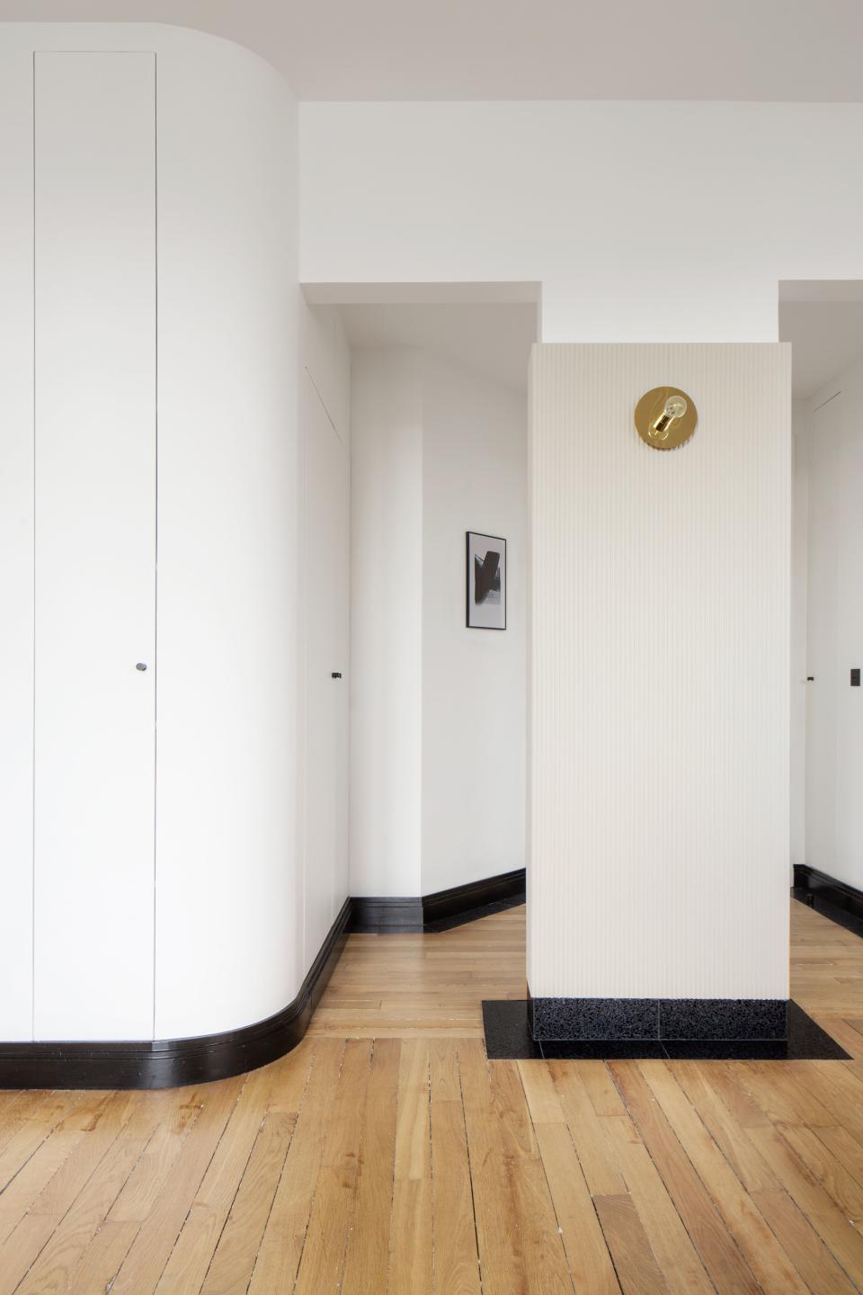 “This pillar was impossible to demolish,” Rebecca says. “So we had to play with it.” Among her eye-catching additions: textured wood and a spectacular terrazzo base that continues onto the floor.