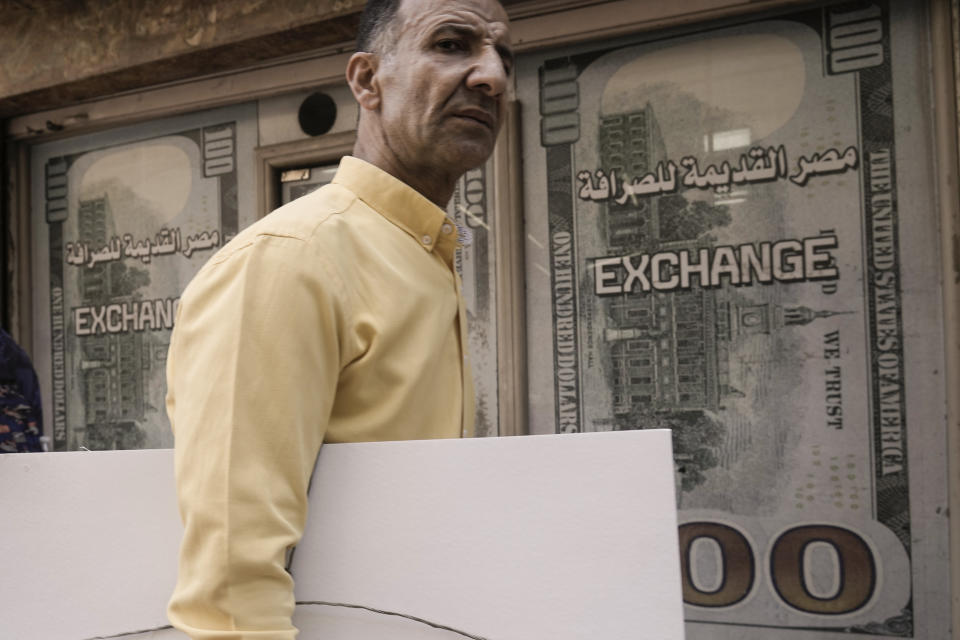 An Egyptian walks past an exchange office in Cairo, Egypt, Wednesday, March 6, 2024. The Egyptian pound slipped sharply against the dollar on Wednesday after the Central Bank of Egypt raised its main interest rate and said it would allow the currency's exchange rate to be set by market forces. (AP Photo/Amr Nabil)