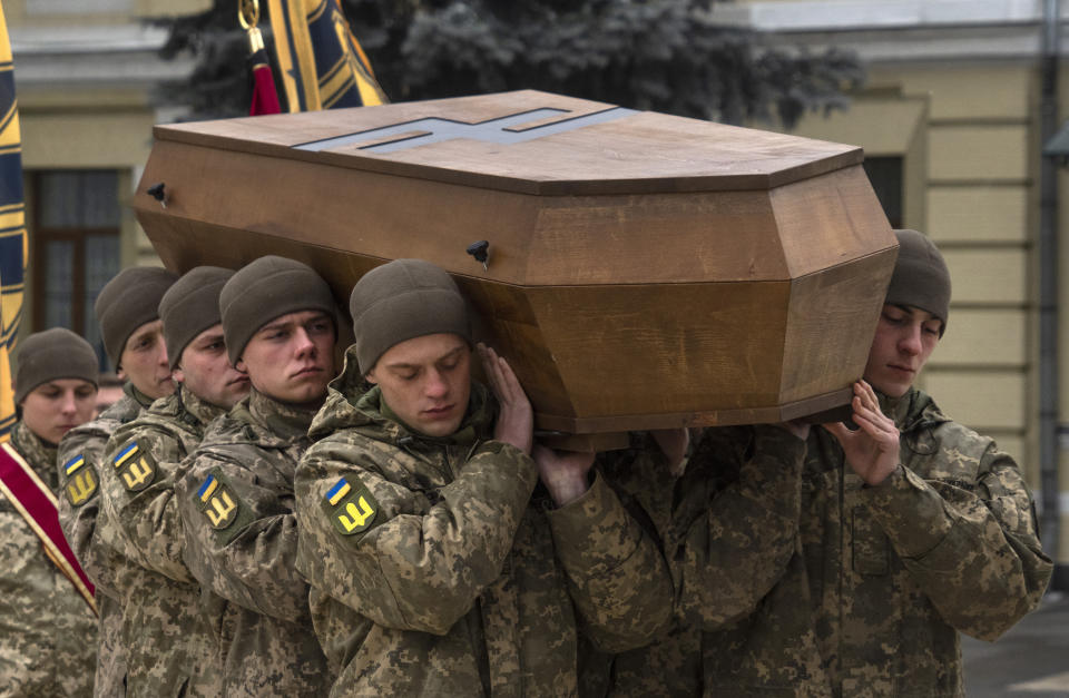 Soldiers carry a coffin of Oleksandr Grianyk of Azov regiment, who was killed on May 8 defending Mariupol from the Russian invaders, during the funeral ceremony in St. Michael Cathedral in Kyiv, Ukraine, Saturday, Jan. 14, 2023. His remains were identified recently. Azov emblem is on the coffin lid. (AP Photo/Efrem Lukatsky)