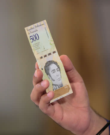 Venezuela's President Nicolas Maduro holds a bank note of the new Venezuela's currency Bolivar Soberano (Sovereign Bolivar) as he speaks during a meeting with ministers at Miraflores Palace in Caracas, Venezuela July 25, 2018. Miraflores Palace/Handout via REUTERS