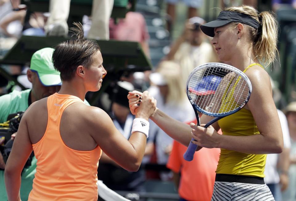 Maria Sharapova, of Russia, right, shakes hands with Kirsten Flipkens, of Belgium, after winning 3-6, 6-4, 6-1 at the Sony Open tennis tournament, Monday, March 24, 2014, in Key Biscayne, Fla. (AP Photo/Lynne Sladky)