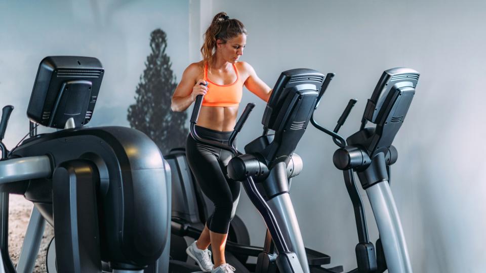 a photo of a woman using an elliptical machine