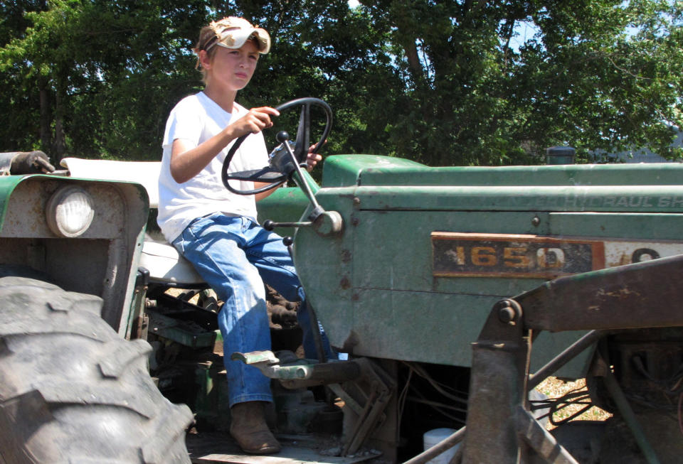 In a June 20, 2012, photo ten-year-old Jacob Mosbacher guides a tractor through a bean field on his grandparents' property near Fults, Ill. Agriculture organizations and federal lawmakers from farm states succeeded last spring in convincing the U.S. Labor Department to drop proposals limiting farm work by children such as Jacob, whose parents say such questions of safety involving kids should be left to parents. (AP Photo/Jim Suhr)