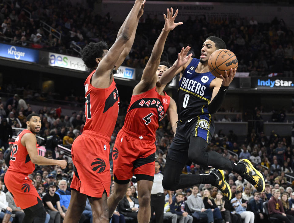 Indiana Pacers guard Tyrese Haliburton (0) jumps in front of Toronto Raptors players during the second half of an NBA basketball game, Saturday, Nov. 12, 2022, in Indianapolis, Ind. (AP Photo/Marc Lebryk)
