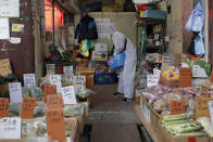 A worker wearing a protective suit sprays disinfectant as a precaution against the COVID-19 at a market in Seoul, South Korea, Wednesday, Feb. 26, 2020. The number of new virus cases in South Korea jumped again Wednesday and the first U.S. military soldier tested positive, with his infection and many others connected to a southeastern city where the outbreak has clustered. (AP Photo/Lee Jin-man)