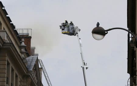 French firefighters work to tackle a fire on the roof of the luxury Ritz Paris hotel at the Place Vendome, central Paris, January 19, 2016. REUTERS/Jacky Naegelen