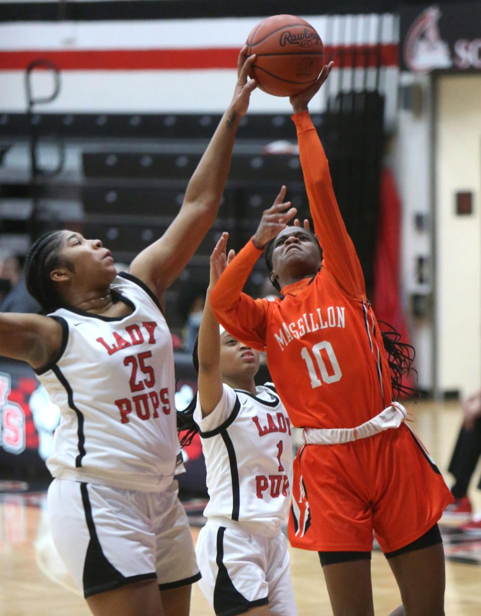 Telai Mealy (10) of Massillon takes a shot while being defended by X'Zariya Fannin (25) of McKinley during their game at McKinley on Monday.