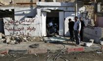 People gather at the site of a car bomb attack in the Risala district in Baghdad December 15, 2013. At least 17 people, most of them Shi'ite Muslims, were killed in a wave of bombings and shootings across Iraq on Saturday ahead of a major Shi'ite ritual, medical and police sources said. The deadliest of the attacks took place in Baghdad's mainly Shi'ite district of Risala when a car bomb blew up near a gathering of Shi'ite pilgrims, killing seven people and wounding another 16, police and medics said. (REUTERS/Thaier Al-Sudani)