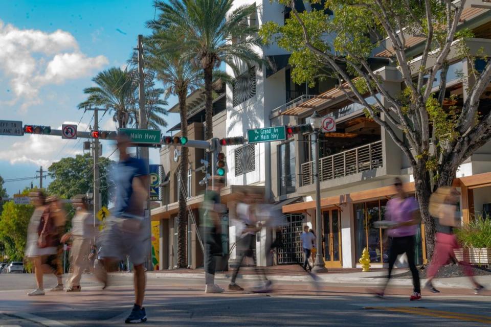 People cross Grand Avenue in Coconut Grove, where gentrification continues to wipe out its historic Black neighborhood. File photo from Dec. 28, 2022.