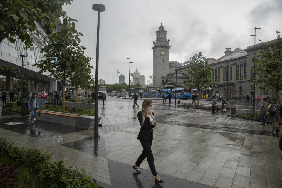 FILE - In this Thursday, July 10, 2021 file photo, a woman wearing a face walks in a street in Moscow, Russia. Moscow’s mayor on Saturday, June 12 ordered a week off for some workplaces and imposed restrictions on many businesses to fight coronavirus infections that have more than doubled in the past week. (AP Photo/Pavel Golovkin, file)