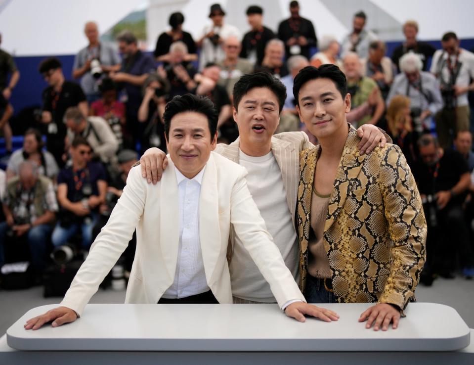 Lee (left) with Kim Hee-won and Ju Ji-hoon in Cannes on 22 May 2023 (AP)