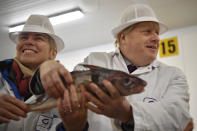 Britain's Prime Minister and Conservative Party leader Boris Johnson, right, visits Grimsby fish market in Grimsby, northeast England, Monday Dec. 9, 2019, ahead of the general election on Dec. 12. All 650 seats in the House of Commons are up for grabs Thursday when voters will pass judgement on a divisive election that will determine Britain's future with European Union. (Ben Stansall/Pool via AP)