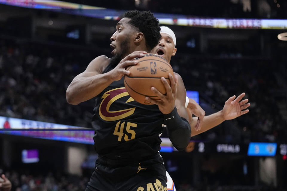 Cleveland Cavaliers guard Donovan Mitchell (45) moves past New York Knicks guard Josh Hart during the first half of an NBA basketball game Tuesday, Oct. 31, 2023, in Cleveland. (AP Photo/Sue Ogrocki)