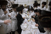 Yaakov Tabersky, right, presented his firstborn son, Yossef on a silver platter to Jewish priests from the Lelov Hassidic dynasty, during the "Pidyon Haben" ceremony in Beit Shemesh, Israel, Thursday, Sept. 16, 2021. The Pidyon Haben, or redemption of the firstborn son, is a Jewish ceremony hearkening back to the biblical exodus from Egypt. (AP Photo/Oded Balilty)