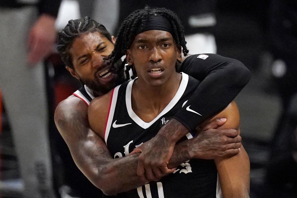 Los Angeles Clippers guard Terance Mann, right, celebrates with guard Paul George after scoring and drawing a foul during the first half in Game 6 of a second-round NBA basketball playoff series against the Utah Jazz.