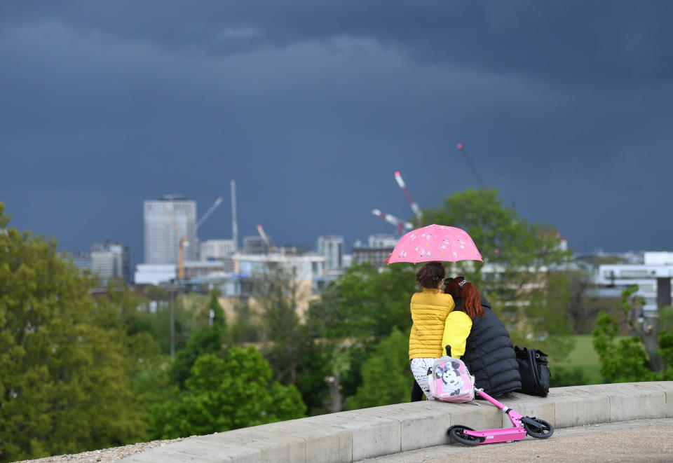 <p>People looking at storm clouds over London from Primrose Hill. Picture date: Tuesday May 18, 2021.</p>
