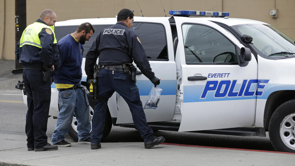 Everett Police officers arrest a man with an outstanding warrant near the Smith Ave. Bridge in Everett, Washington, which is a constant gathering place for homeless people battling addiction and mental illness. The hardcore homeless represent a major financial burden on Everett, putting pressure on jail, emergency room and other services. (Photo: ASSOCIATED PRESS)