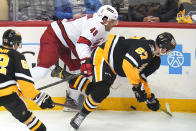 Pittsburgh Penguins' Radim Zohorna (67) is checked off the puck by Carolina Hurricanes' Jordan Martinook (48) during the first period of an NHL hockey game in Pittsburgh, Sunday, March 13, 2022. (AP Photo/Gene J. Puskar)