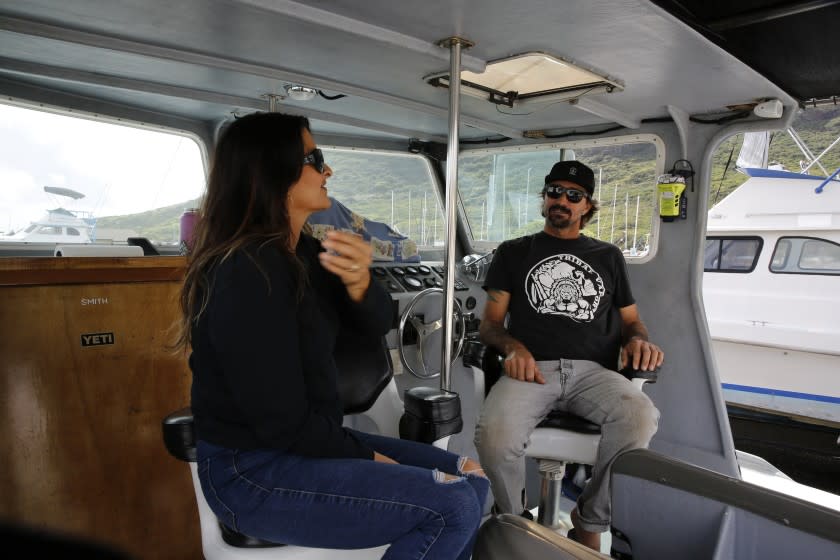 Cynthia and Lance Keener, owners of Ohana Fishing Charters, sit on their boat in Lihue, Hawaii, Thursday, March 4, 2021. The rural island in Hawaii is one of the world's most sought-after vacation destinations, but it has been nearly impossible to visit for most of the past year because of quarantine and other coronavirus restrictions. Keener said he lost nearly all of his business when the county shut down last March. Things haven't gotten any better, and he looks forward to when the state lifts restrictions in April. (AP Photo/Caleb Jones)