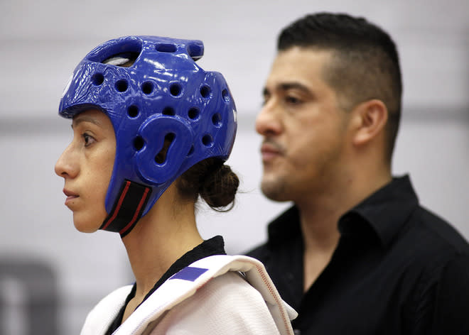 Diana Lopez, left, gets ready to square off against Danielle Holmquist as her older brother and coach Jean Lopez stands in the background during the 2012 Taekwondo Olympic Trials at the U.S. Olympic Training Center on March 10, 2012 in Colorado Springs, Colorado. Lopez won the match 3-1. (Photo by Marc Piscotty/Getty Images)