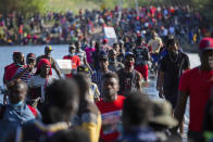 Haiti migrants waiting in Del Rio and Ciudad Acuña to get access to the United States, cross the Rio Grande toward Ciudad Acuña to get supplies, Friday, Sept. 17, 2021, in Ciudad Acuña, Mexico. Haitians crossed the Rio Grande freely and in a steady stream, going back and forth between the U.S. and Mexico through knee-deep water with some parents carrying small children on their shoulders. Unable to buy supplies in the U.S., they returned briefly to Mexico for food and cardboard to settle, temporarily at least, under or near the bridge in Del Rio, a city of 35,000 that has been severely strained by migrant flows in recent months. (Marie D. De Jesús/Houston Chronicle via AP)