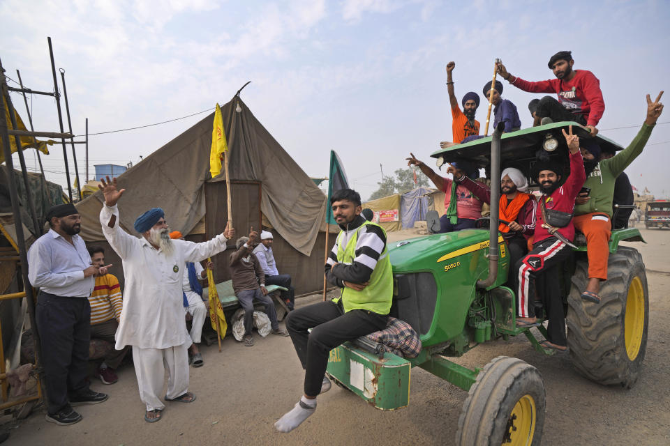 Farmers celebrate news of the repeal of farm laws they were protesting against, in Singhu, on the outskirts of New Delhi, India, Friday, Nov. 19, 2021. Prime Minister Narendra Modi has said his government will withdraw the controversial farm laws that were met with year-long demonstrations from tens of thousands of farmers who said the laws will shatter their livelihoods. The drawn-out demonstrations have posed one of the biggest political challenges to Modi, who swept the polls for the second time in 2019. (AP Photo/Manish Swarup)