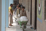 In this Aug. 25, 2019, file photo, displaced Yemenis receive food supplies provided by the World Food Programme, at a school in Sanaa, Yemen. The World Food Program chief warned Thursday, Sept. 17, 2020, that millions of people are closer to starvation because of the deadly combination of conflict, climate change and the COVID-19 pandemic and he urged donor nations and billionaires to help feed them and ensure their survival. (AP Photo/Hani Mohammed, File)