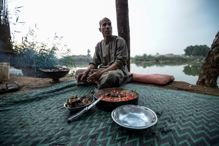 An Egyptian fisherman prepares a meal next to the "Pharaonic Sea"