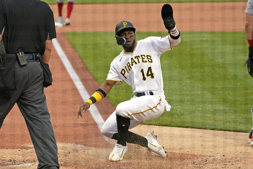 Pittsburgh Pirates' Rodolfo Castro (14) scores against the Cincinnati Reds during the second inning of a baseball game in Pittsburgh, Saturday, May 14, 2022. (AP Photo/Gene J. Puskar)