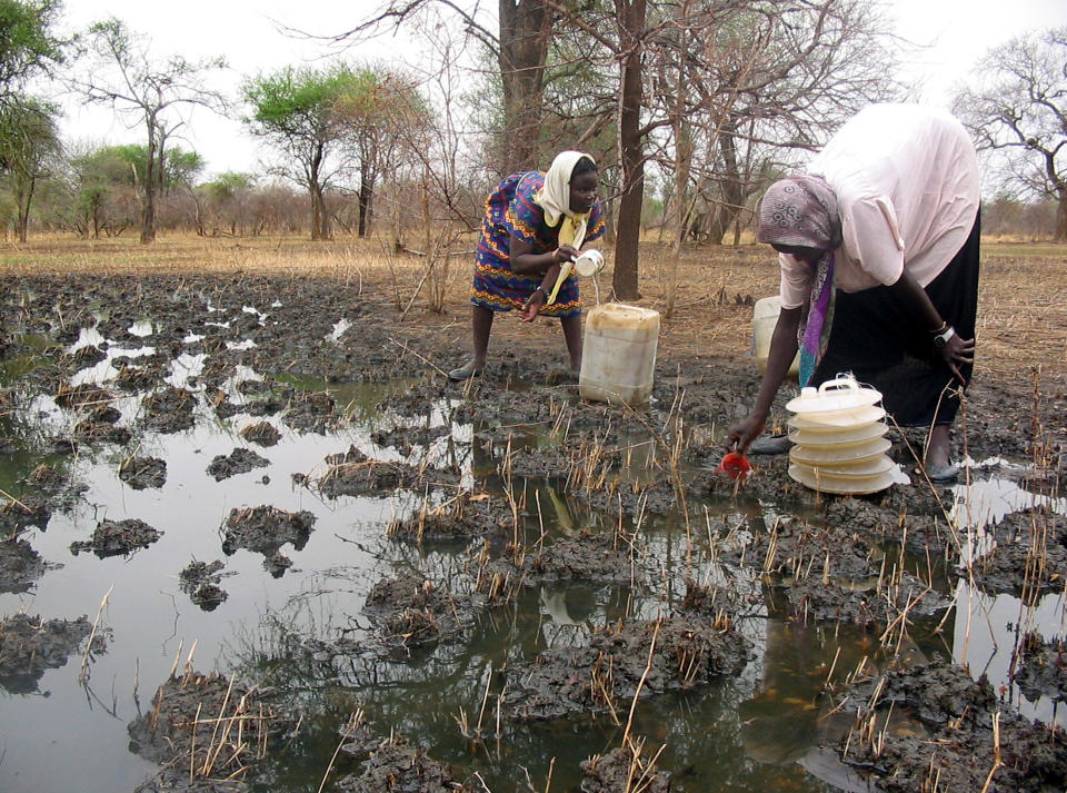 Internally displaced Sudanese women collect rainwater to be used for drinking and cooking in southern Sudan. Internally displaced Sudanese women from Mahli village in southern Darfur region collect rainwater to be used for drinking and cooking as they now live in an improvised refugee camp near Jaach village, northern Awil county in southern Sudan April 26, 2005.&nbsp;