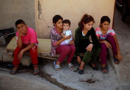 Yazidis children sit outside their house in Sinjar region, Iraq August 2, 2017. REUTERS/Suhaib Salem