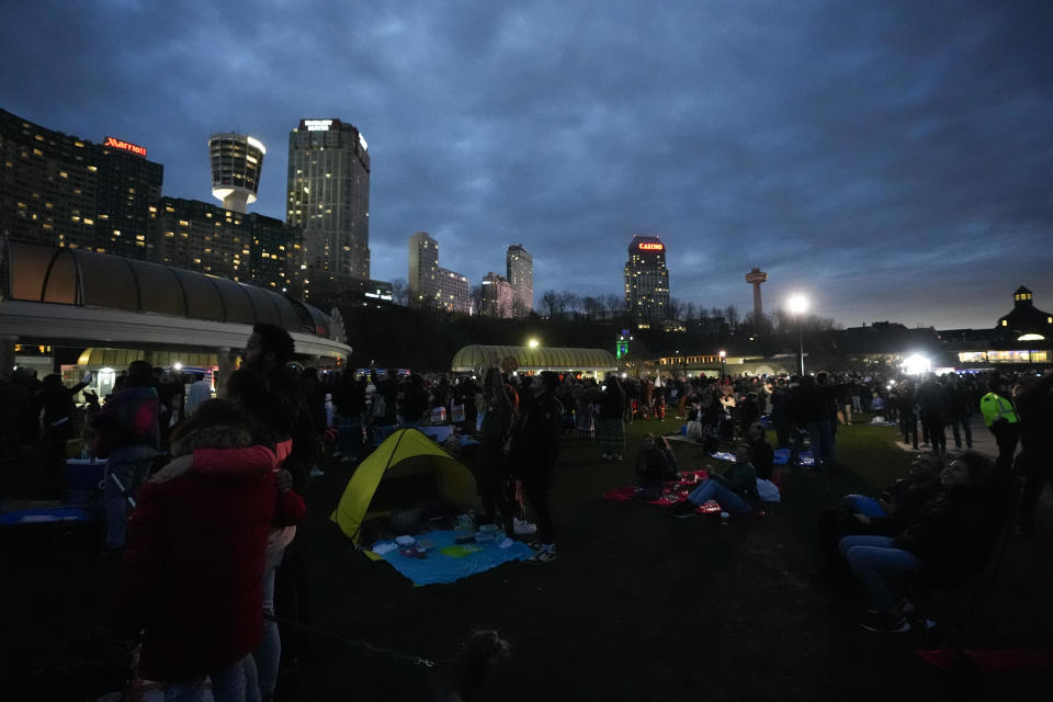 People look toward the sky as the moon begins to eclipse the sun on April 8, 2024, in Niagara Falls, Ontario, Canada. / Credit: Mert Alper Dervis/Anadolu via Getty Images