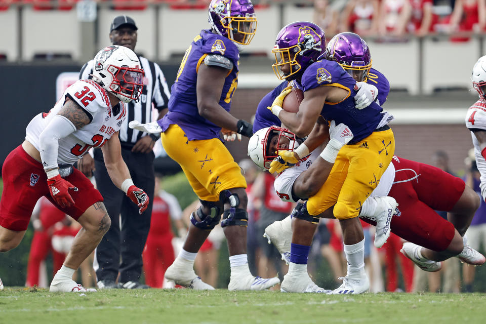 East Carolina's Ryan Jones (4) tries to break a tackle by North Carolina State's Savion Jackson (9) during the second half of an NCAA college football game in Greenville, N.C., Saturday, Sept. 3, 2022. (AP Photo/Karl B DeBlaker)