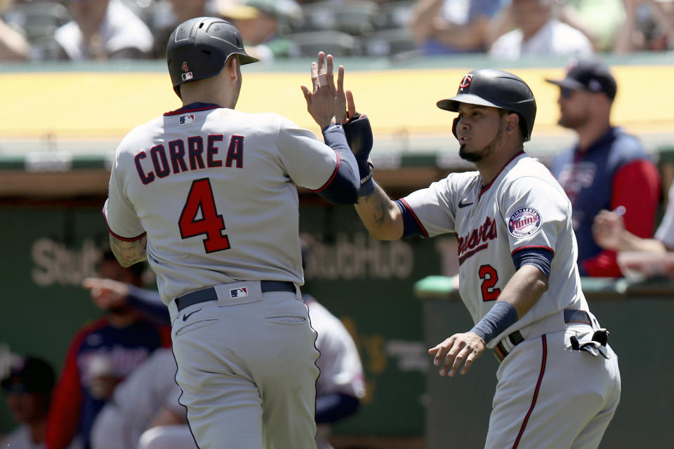 Minnesota Twins' Luis Arraez (2) congratulates Carlos Correa (4) after they score in the first inning of a baseball game in Oakland, Calif., on Wednesday, May 18, 2022. (AP Photo/Scot Tucker)