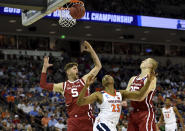 Virginia's Mamadi Diakite (25) after shooting looks for the rebound while defended by Oklahoma's Matt Freeman (5) and Brady Manek (35) during the second half of a second round men's college basketball game in the NCAA Tournament in Columbia, S.C. Sunday, March 24, 2019. (AP Photo/Richard Shiro)