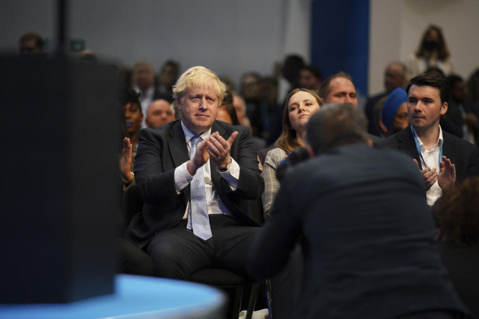 Britain's Prime Minister Boris Johnson applauds as Chancellor of the Exchequer Rishi Sunak speaks during the Conservative Party Conference in Manchester, England, Monday, Oct. 4, 2021. (Peter Byrne/PA via AP)