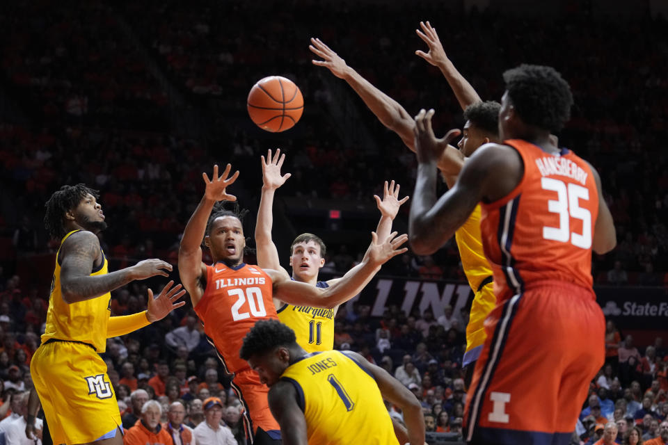 Illinois' Ty Rodgers (20) passes to Amani Hansberry (35) as Marquette's Tre Norman, left, Tyler Kolek (11) and Kam Jones defend during the first half of an NCAA college basketball game Tuesday, Nov. 14, 2023, in Champaign, Ill. (AP Photo/Charles Rex Arbogast)