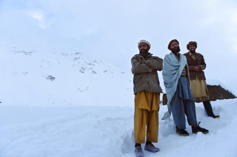 Relatives walk down from the site of an avalanche after searching for victims in the district of Bazarak, Panjshir province, on February 25, 2015