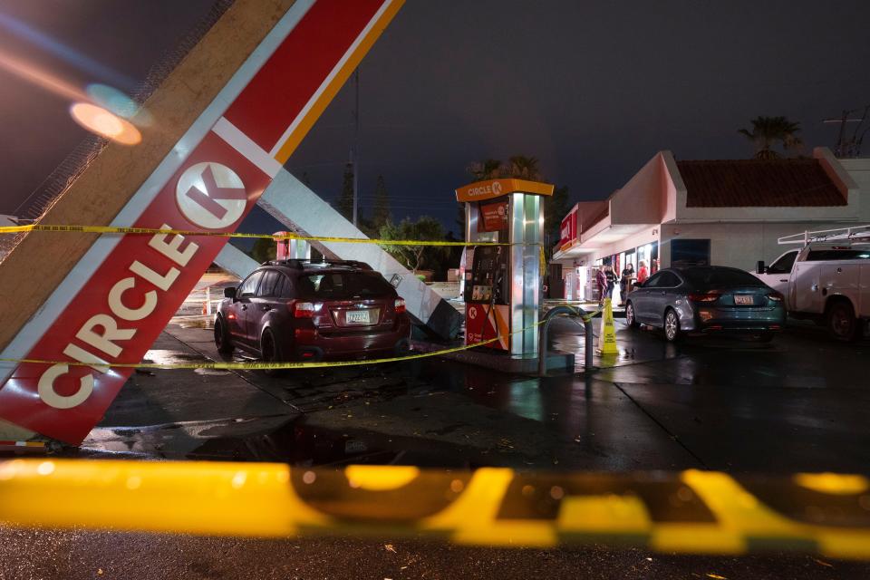 A car is sits under the debris of a fallen gas station awning after a storm passed through north Phoenix near the intersection of Seventh Street and Coral Gables Drive on Saturday, July 30, 2022.