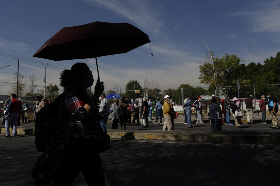 Residents of the Iztacalco borough follow a long, snaking line to receive doses of the Russian COVID-19 vaccine Sputnik V, during a mass vaccination campaign for Mexicans over age 60, at the Advanced School for Physical Education, in Mexico City, Wednesday, Feb. 24, 2021. (AP Photo/Rebecca Blackwell)