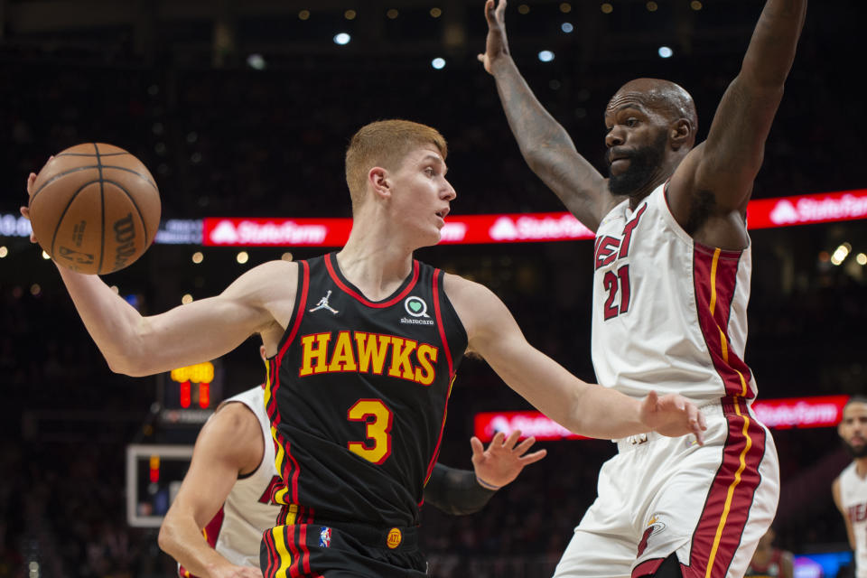 Atlanta Hawks guard Kevin Huerter (3) looks to pass the ball with Miami Heat center Dewayne Dedmon (21) defending during the first half of an NBA basketball game Friday, Jan. 21, 2022, in Atlanta. (AP Photo/Hakim Wright Sr.)