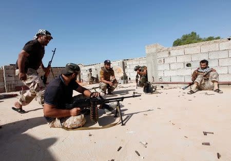 Fighters from forces aligned with Libya's new unity government are pictured on the rooftop of a house in the Zaafran area during clashes with Islamic State fighters positioned in Sirte June 30, 2016. REUTERS/Ismail Zitouny