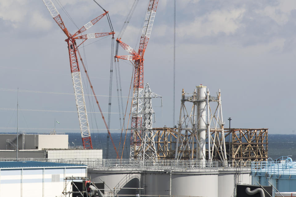 This photo shows the damaged Unit 1 reactor, back, and part of the exhaust stack shared with the Unit 1 and 2 reactors at the Fukushima Daiichi nuclear power plant in Okuma town, Fukushima prefecture, northeastern Japan, Saturday, Feb. 27, 2021. The exhaust stack has gotten its upper half cut off due to safety concerns. (AP Photo/Hiro Komae)