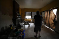 Resident Alan Mereschal stands in what is left of his home after flooding in Vaux-sous-Chevremont, Chaudfontaine, Belgium, Saturday, July 24, 2021. Mereschal, in an effort to help himself psychologically during the flooding, turned to helping others in using his language skills to help translate between residents and rescue personnel. (AP Photo/Virginia Mayo)