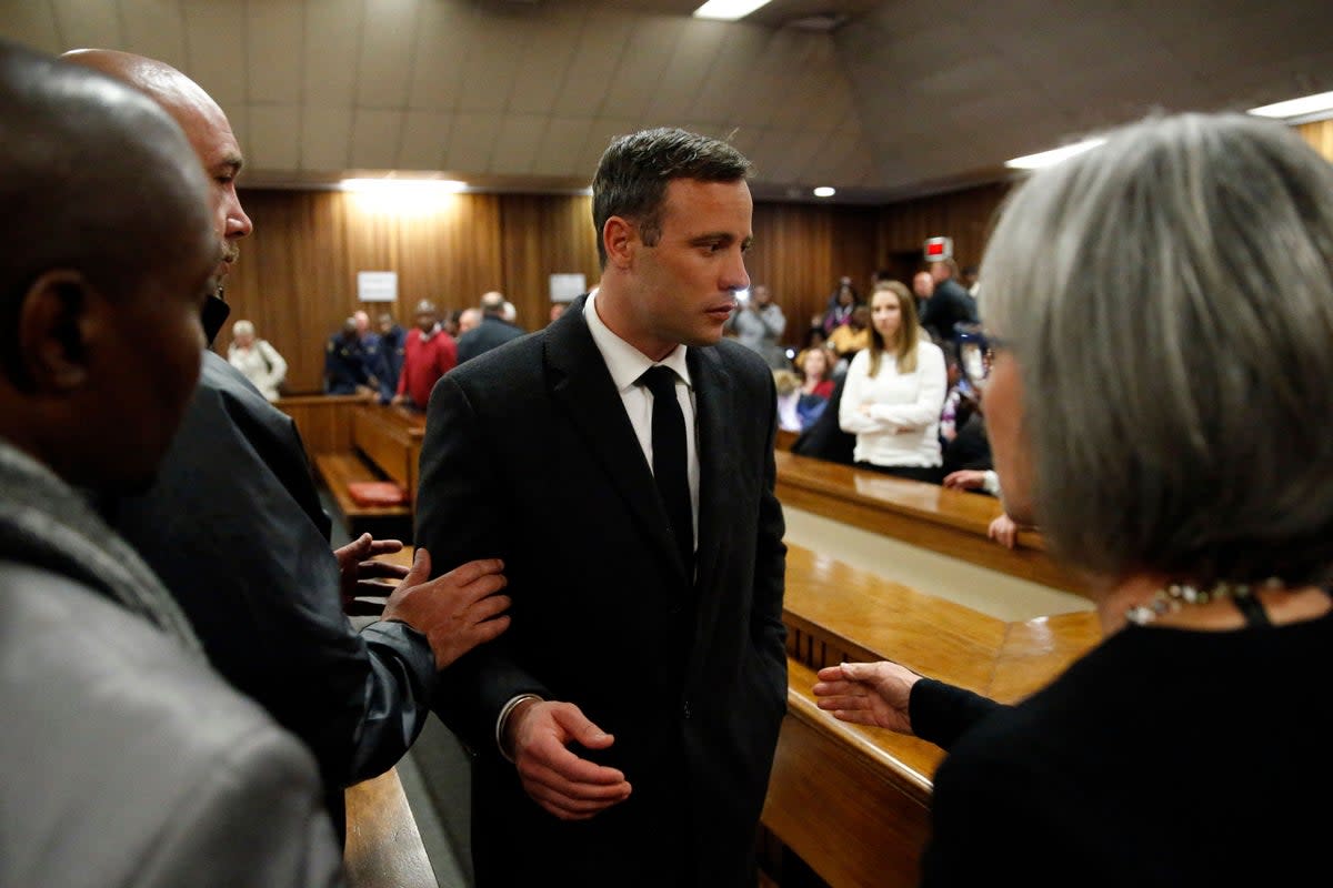 Oscar Pistorius speaks with relatives as he leaves the High Court in Pretoria in 2016  (AFP via Getty Images)