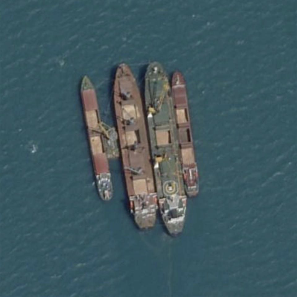 This Planet Labs satellite image shows a ship-to-ship transfer in the Kerch Strait, between Crimea and Russia, on July 18, 2022. Satellite imagery and transponder data reviewed by The Associated Press shows numerous large cargo ships anchored off the Russian coast rendezvousing with smaller ships shuttling grain from both occupied Ukrainian ports in Crimea and Russian ports, obscuring the true origin of the cargo. Those larger ships then carried the blended grain to ports in Egypt, Libya, Iraq and Saudi Arabia. (Planet Labs via AP)