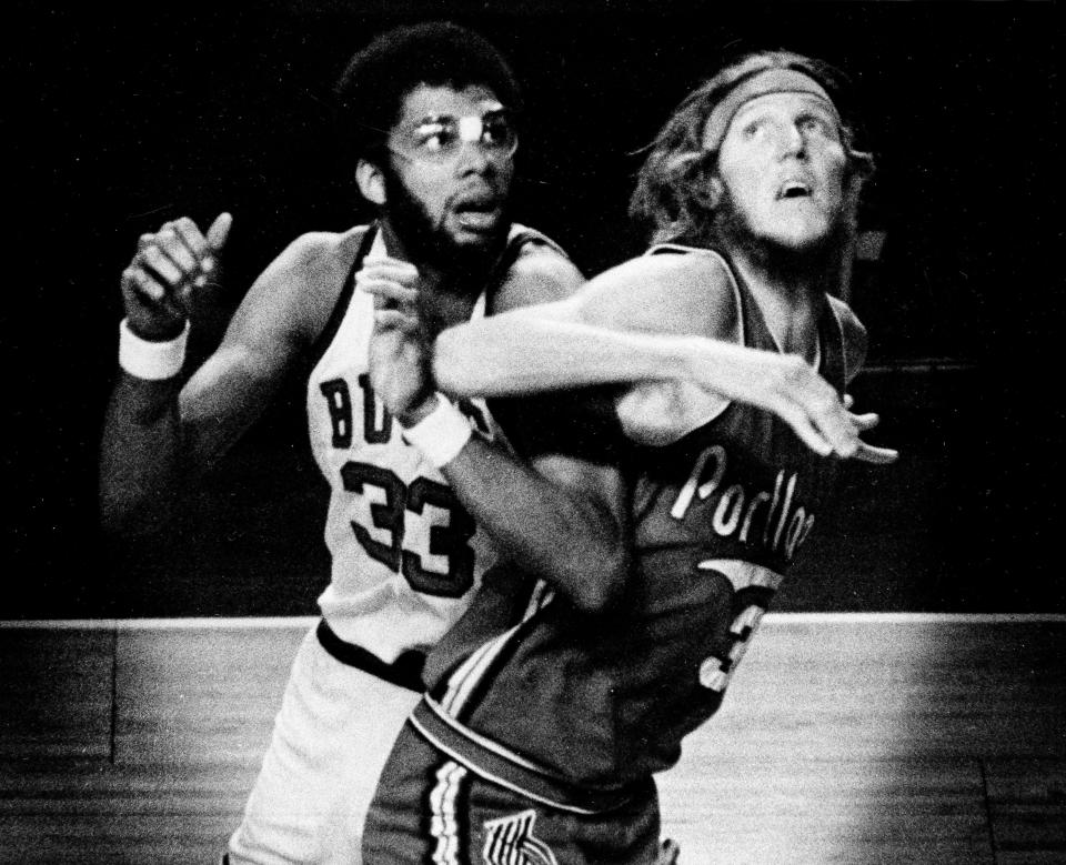 Bill Walton and Kareem Abdul-Jabbar battle for position in a game in 1975.